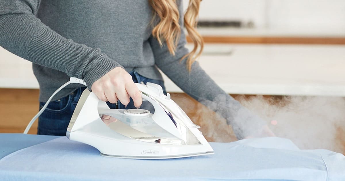 اتوی سنتی روی میز اتو، با بخار در حال کار